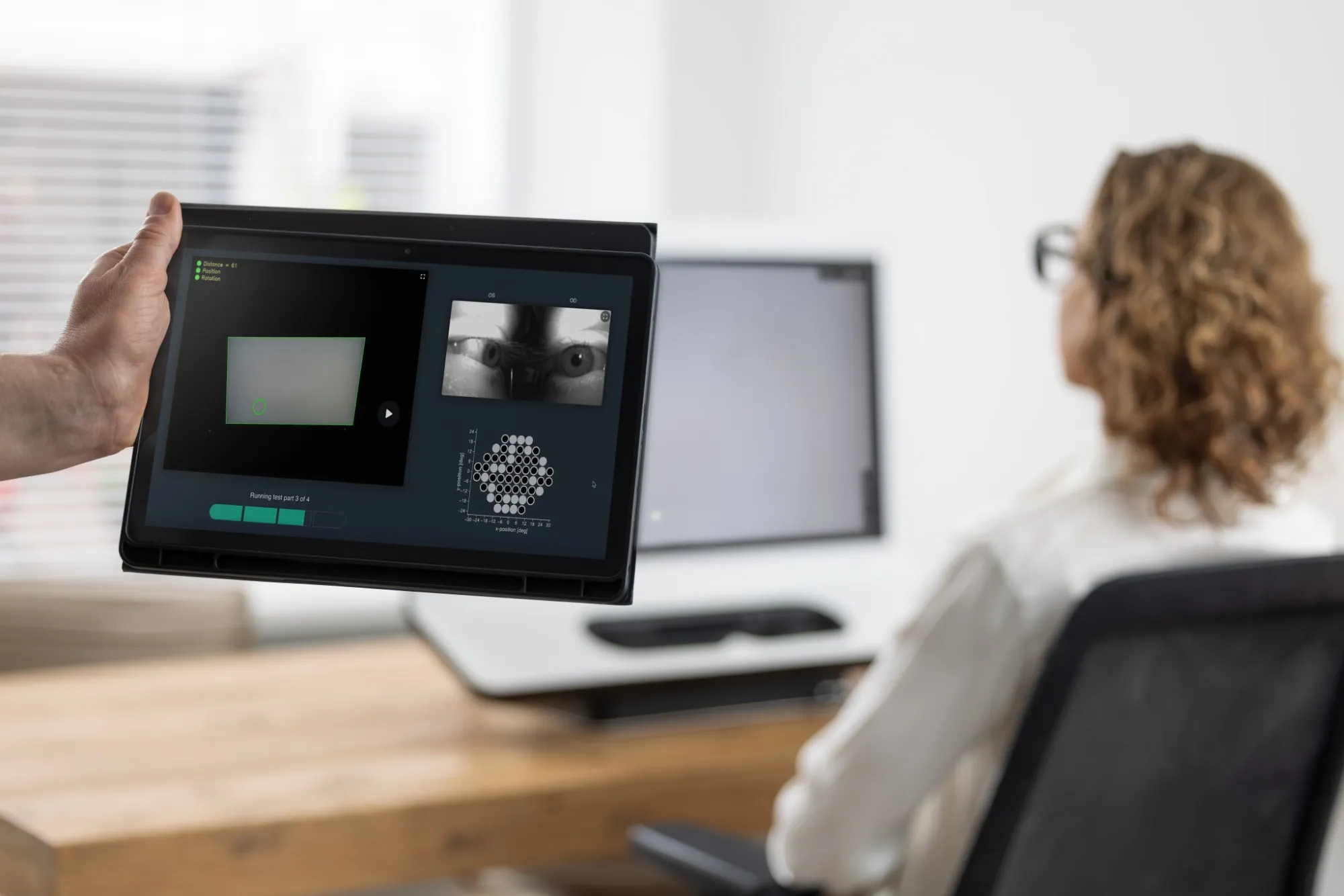 SONDA running on a tablet held by an operator, with the customer seated in front of the display in the background