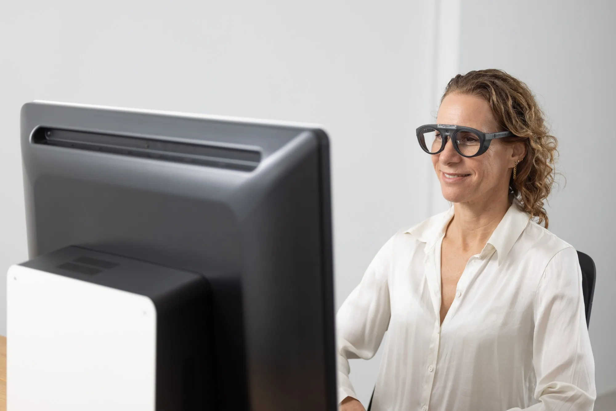 Patient wearing the SONDA glasses, seated in front of the SONDA Hub display
